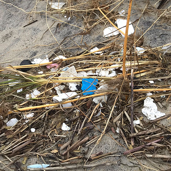 broken pieces of styrofoam littering sand dunes