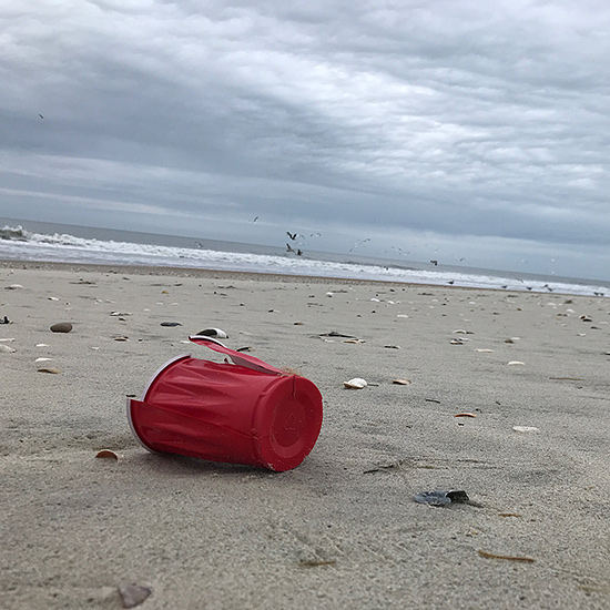 discarded plastic cup litter on OBX beach